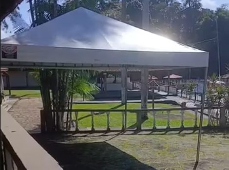 Tenda branca montada em área verde para evento